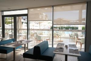 a restaurant with tables and chairs and a large window at Zephyr Agadir in Agadir