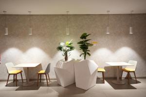a room with tables and chairs and a plant at Zephyr Agadir in Agadir