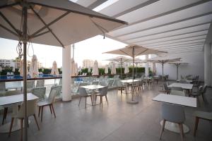 a restaurant with white tables and chairs and umbrellas at Zephyr Agadir in Agadir