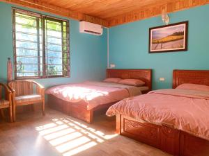 two beds in a room with blue walls at Thanh Truc House in Sa Pa