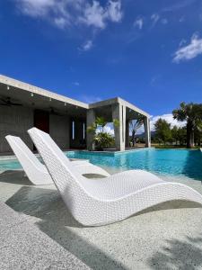 a white lounge chair sitting next to a swimming pool at 135 會館 135 Private Villa Yilan in Dongshan