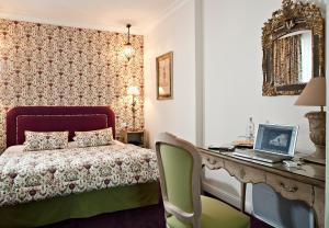 a bedroom with a bed and a desk with a laptop at Best Western Plus Hotel Villa D'est in Strasbourg