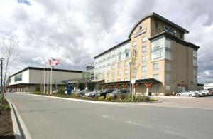 un gran edificio con coches estacionados en un estacionamiento en Coast Hotel & Convention Centre en Langley