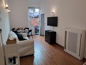 un salon avec un canapé blanc et une télévision dans l'établissement Terrazza nel centro storico, à Rapallo