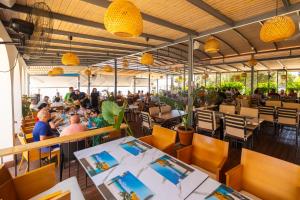 a restaurant with people sitting at tables at Royal Blue Hotel in Dhërmi
