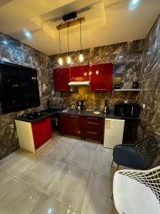 una grande cucina con armadi rossi ed elettrodomestici di Teranga SN a Dakar
