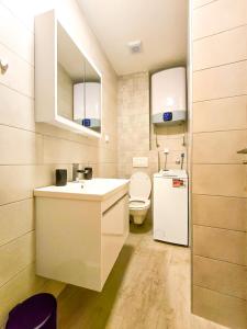 baño pequeño con fregadero y nevera en Juzni Horizont Apartments, en Sutomore