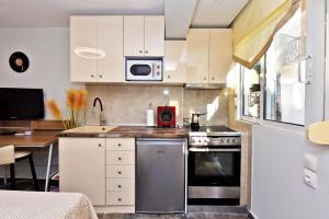 a kitchen with white cabinets and a stove top oven at AMELIA apartment in Nea Moudania +4 photos