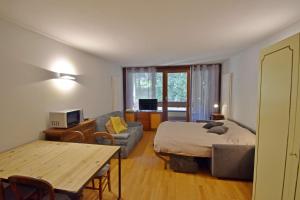 a bedroom with a bed and a couch and a table at Residenza Silvana in Madonna di Campiglio