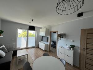 a living room with a table and a couch at Apartament Leśna in Bydgoszcz