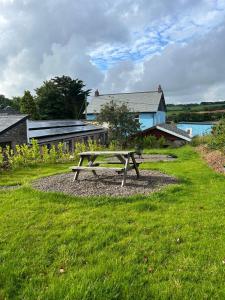 a picnic table sitting in the grass in a field at Yetland Farm Holiday Cottages in Combe Martin