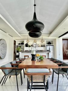 Un comedor con mesa y sillas de madera. en VILLA CELAVI 15, en Kerobokan