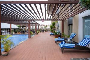 a patio with lounge chairs and a swimming pool at Grand Kakinada by GRT Hotels in Kākināda