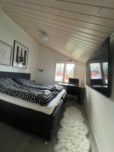 a bedroom with a bed and a desk and a chair at Kulta Villa, keskellä Vuokattia sisältyy Sauna, ilmainen Pysäköinti, Wi-Fi, 65smartTV, oma pieni piha alue, sopii perheille in Vuokatti