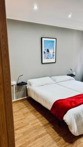 ein Schlafzimmer mit einem Bett, auf dem eine rote Decke liegt in der Unterkunft Casco Vello Vigo Oliva 8 in Vigo