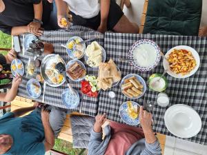 a group of people sitting at a table with food at Eco family guest house in Mlashe