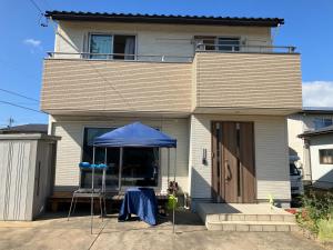 a house with a blue umbrella in front of it at オルちゅーばーハウス#6畳1部屋提供#ホスト居住型民泊#定点カメラにてライブ配信中 in Fukui