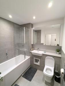 a bathroom with a toilet and a sink and a shower at Modernistic 2 Bed - 2 Bath Flat near Central London in London +2 photos