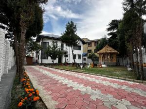 a brick road with orange flowers on the side of a house at Srinagar Luxury Escape - Dilan Residency in Srinagar