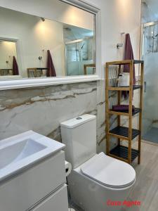 a bathroom with a toilet and a sink and a mirror at Casas Pedro & Agata in Morro del Jable