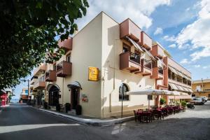 um edifício com mesas e guarda-sóis numa rua em Polydoros Hotel Apartments em Palaiochóra