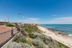 a view of a beach with a street light and the ocean at North Beach Cottage By Swan Bnb Management in Perth