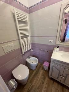 a bathroom with a toilet and a sink at Paganino rooms in Fiumicino +35 photos