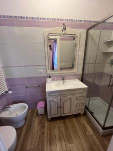 a bathroom with a sink and a toilet and a mirror at Paganino rooms in Fiumicino