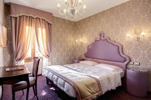1 dormitorio con cama, mesa y lámpara de araña en Domus Cavanis, en Venecia