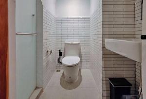 a bathroom with a white toilet and a sink at The Motuga Hostel Bangkok in Bangkok +59 photos