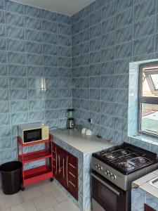 een keuken met blauwe tegelmuren en een fornuis bij Ouslane Appart-1 in Cotonou