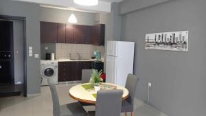 a kitchen with a table and chairs and a white refrigerator at Demmy's Luxury Apartment in Orestiada