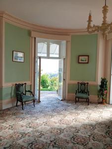 Una habitación vacía con dos sillas y una puerta abierta. en Woodlands, Teignmouth, en Teignmouth