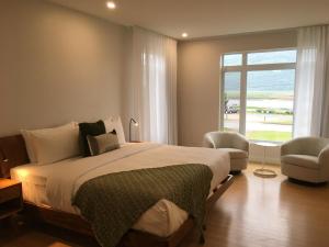 Un dormitorio con una cama grande y una ventana. en Domaine Belle Plage, en Baie-Saint-Paul 100 fotos más