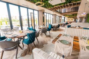 a restaurant with tables and chairs and windows at хотел ADDRESS in Ravda