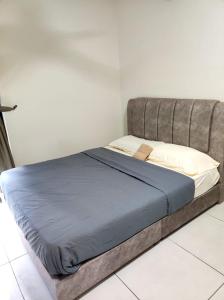 Ce lit se trouve dans une chambre blanche dotée d'une couverture bleue. dans l'établissement Majestic Maxim Cozy Family House, à Kuala Lumpur