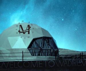 a domed building with a sign on it at night at RUM MARTiN BUBBLES lUXURY CAMP in Wadi Rum +54 photos