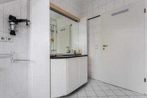 a white bathroom with a sink and a mirror at Sonne, Mond und Sterne in Moritzburg +10 photos