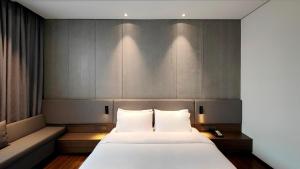 Voodi või voodid majutusasutuse Elong Etang Hotel Guangzhou Baiyun Airport Renhe Railway Station toas