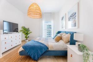 a bedroom with a blue bed and a tv at Modern2BR ElegantYas Island703 in Abu Dhabi