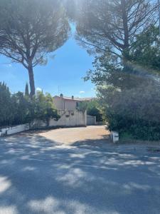 una entrada con árboles y una casa al fondo en Ca de Cartocci, en Arezzo
