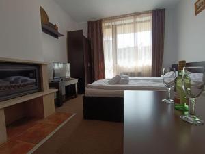 a bedroom with a bed and a television and a table at Студио в хотел Мария Антоанета in Bansko