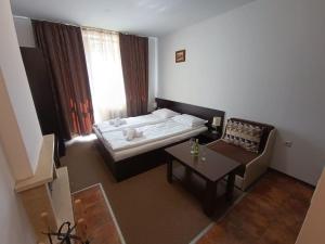 a small room with a bed and a table at Студио в хотел Мария Антоанета in Bansko +11 photos