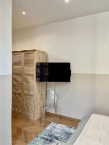 a bedroom with a flat screen tv on a wall at Vera Nizza in Nice