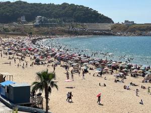 a crowd of people on a beach with umbrellas at apartamiento playa ksar sghire in Tangier