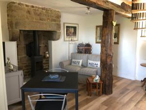 a living room with a couch and a table at The Stable in Sourdeval