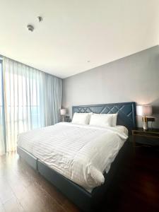 a bedroom with a large bed with white sheets at Condotel The Arena Cam Ranh Light Tower in Dien Khanh