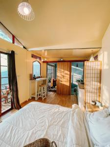 une chambre avec un lit et un bureau et une cuisine dans l'établissement At The Mountain Cottage, Tiny Home at Doichang with Hot tub Included Breakfast and Dinner, à Ban Huai Khai