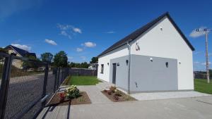 a small white building with a black roof at Bukowska House in Sulechów