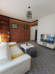 Una sala de estar con un sofá blanco y un televisor. en Apartament ultracentral, en Oradea